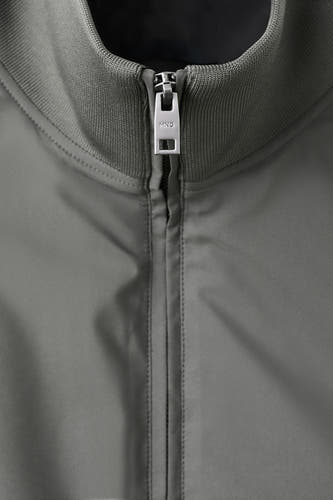 Gilet gris de MANGO, avec une texture lisse et une fermeture éclair argentée à l'avant.