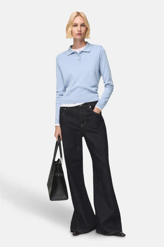 T-shirt bleu avec col rond de MANGO, porté avec des jeans larges et sombres et une sacque.
