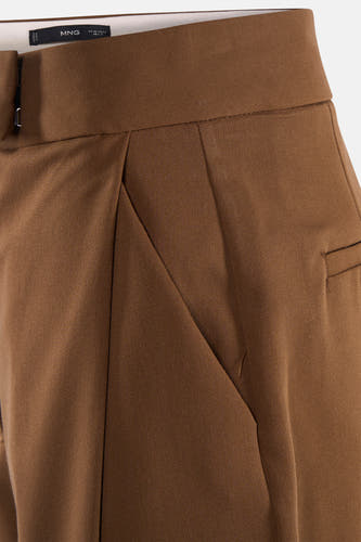 Pantalon coloré de MANGO, avec une ceinture haute, des poches latérales et des plis subtils.