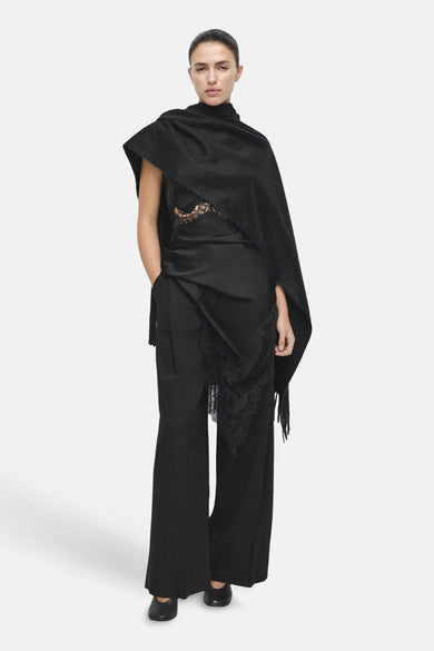 Pantalon noir MANGO, à jambes larges et avec un détail de drapé en satin à franges.