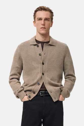 Gilet beige de MANGO, vue sur le dos, porté avec un pantalon noir.