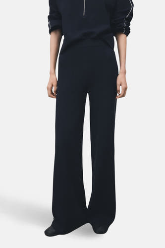Pantalon bleu de MANGO, avec des jambes larges et une bande contrastante sur le côté, vu de derrière.