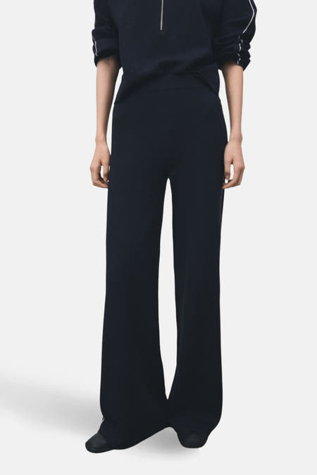 Pantalon bleu de MANGO, avec des jambes larges et une bande contrastante sur le côté, vu de derrière.