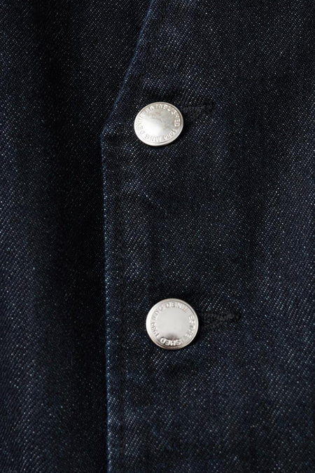 Combinaison en denim bleu marine de MANGO, avec des boutons argentés comme détail.