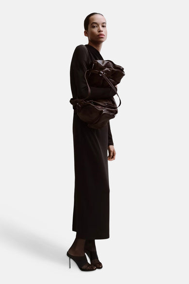 Bruin kleedje met lange mouwen van MANGO, maxi-lengte, gestyled met donkerbruine tassen en zwarte muiltjes.
