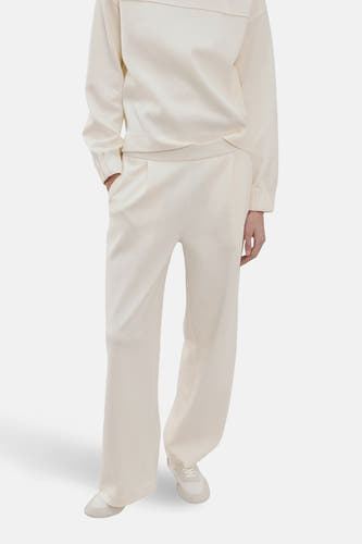 Ecru sweater van MANGO, met lange mouwen en een brede halslijn, gedragen met crèmekleurige broek en sneakers.