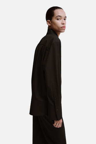 Chemise marron à manches longues de MANGO, vue rapprochée de profil d'un mannequin avec une tenue unie.