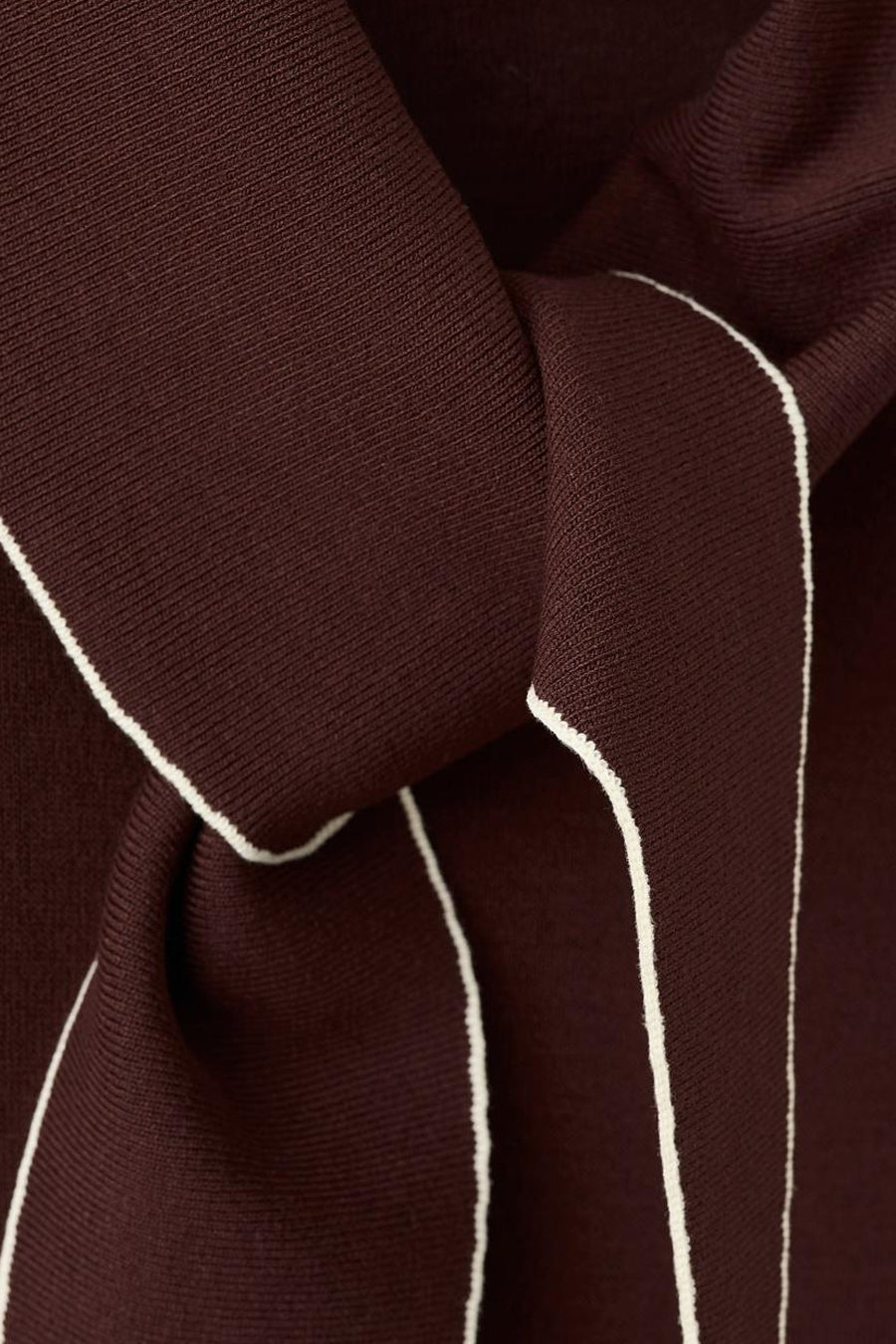 Blouse sans manches marron de MANGO, avec passepoil blanc le long des bords et tissu drapé.