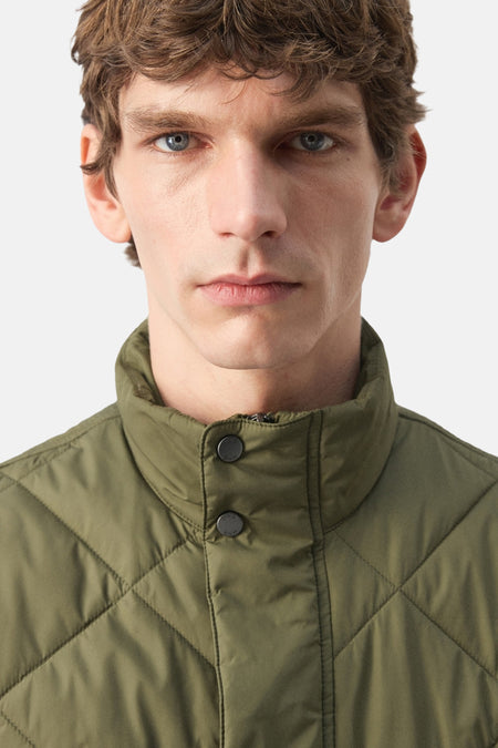 Gilet vert de MANGO avec un matelassage en losange et une fermeture à boutons.