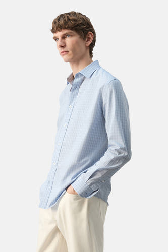 Chemise multicolore à manches longues de MANGO, avec un motif à carreaux subtil, portée avec un pantalon clair et vue de côté.