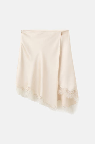 Jupe courte beige de MANGO, finie avec de la dentelle blanche à l'ourlet.