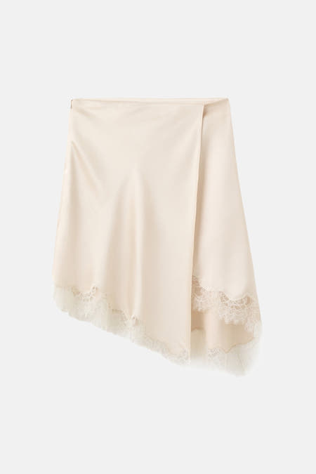 Beige korte rok van MANGO, afgewerkt met wit kant aan de zoom.