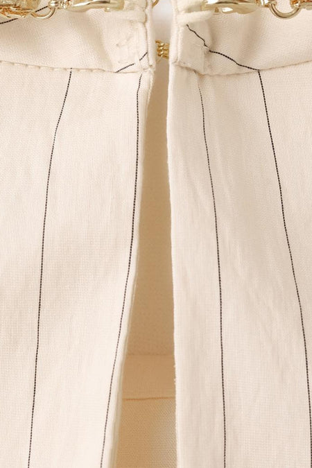 Blouse écru sans manches de MANGO, avec fines rayures verticales et détails décoratifs dorés.
