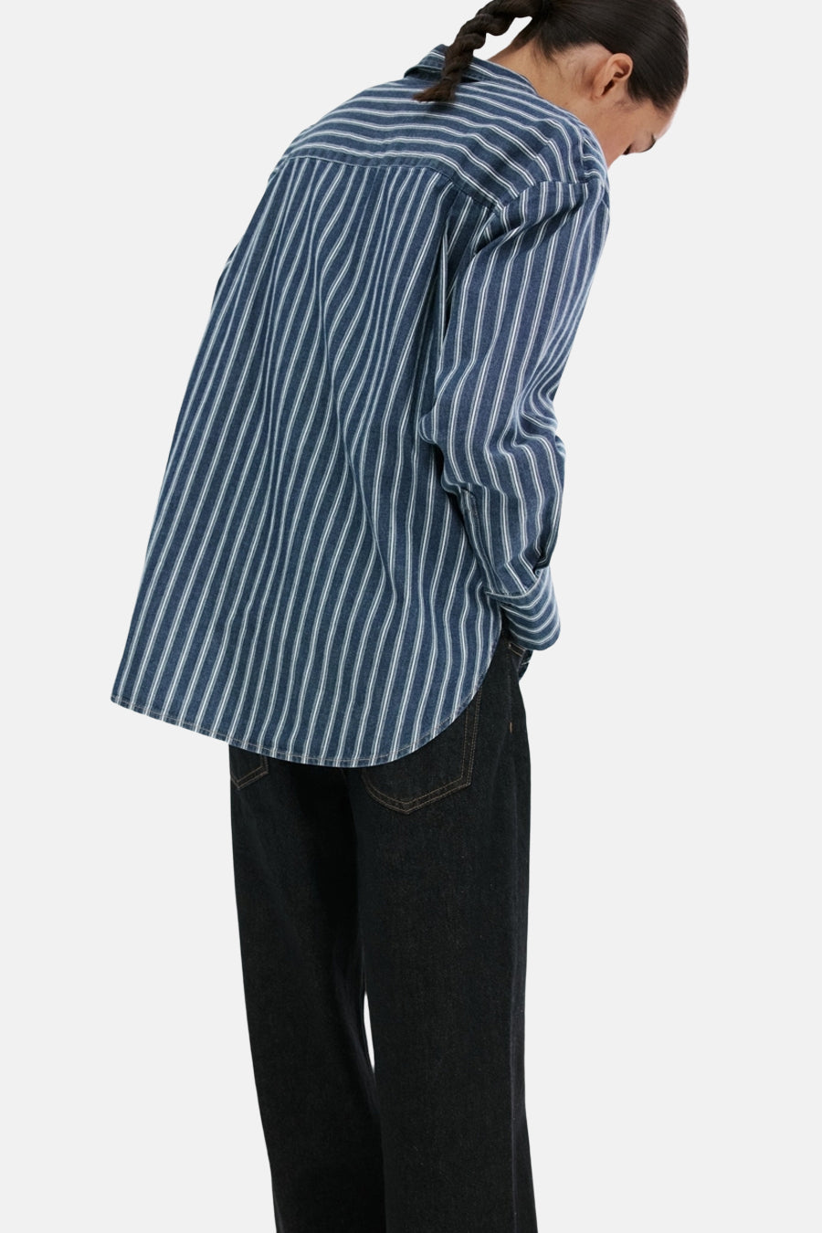 Donkerblauw denim overhemd van MANGO, met verticale witte strepen, te zien van achteren met donkere jeans.

