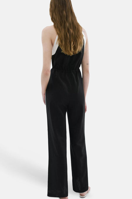 Combinaison noire à bretelles blanches de MANGO, vue de dos avec taille élastique et jambes larges.