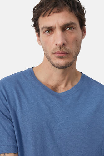 T-shirt bleu à manches courtes de MANGO, gros plan sur un homme avec une barbe de trois jours et un t-shirt bleu uni.