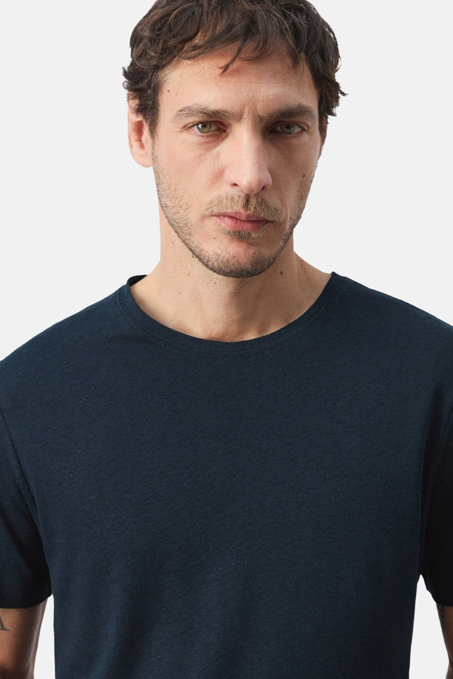 T-shirt bleu à manches courtes de MANGO, gros plan sur un homme portant un t-shirt uni.