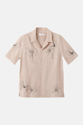 Chemise beige à manches courtes de MANGO, avec des motifs floraux noirs esquissés et un col cubain.