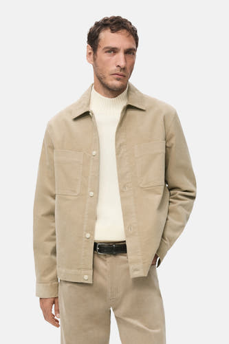 Chemise beige à longues manches de MANGO, vue de derrière, associée à un pantalon de la même couleur.