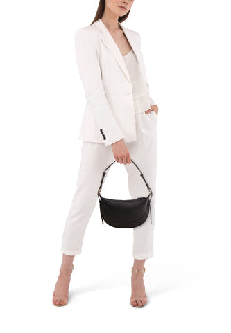 Sac à dos noir de MANGO, porté par un modèle en pantalon blanc et blazer.