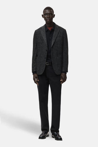 Blazer multicolore de MANGO porté avec un t-shirt noir, un pantalon noir et des loafers noirs.