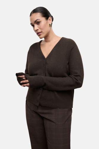 Veste brune de MANGO sur une pile de papier brun.