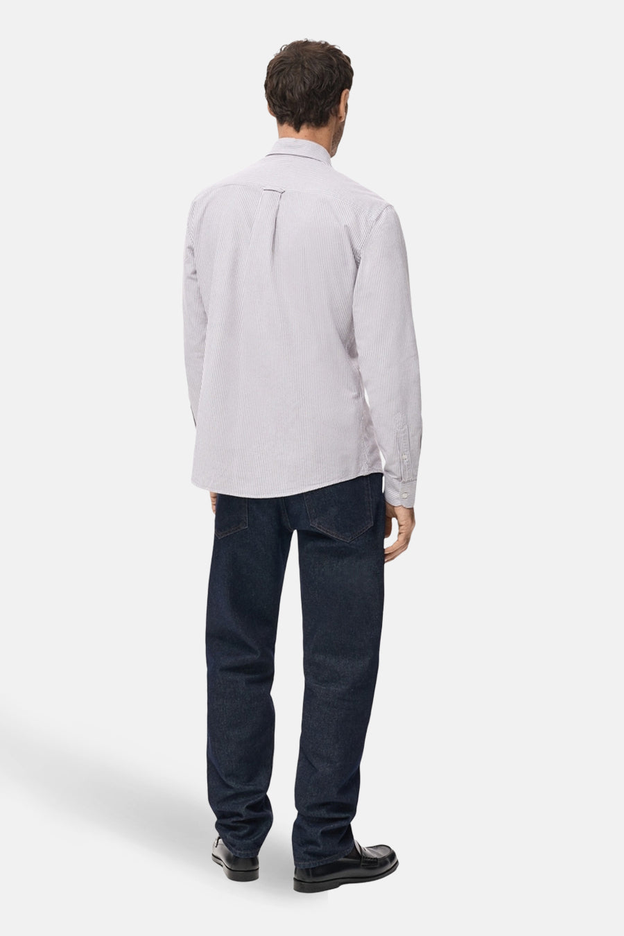 Man van achter, gestreept shirt, blauwe jeans, zwarte schoenen.