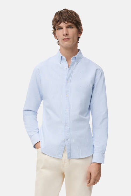 Chemise bleue rayée à manches longues de MANGO, vue de dos, portée avec un pantalon beige.