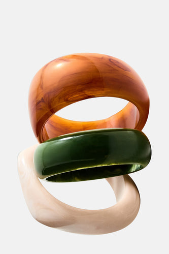 Gestapelde armbanden in bruin, groen en beige.