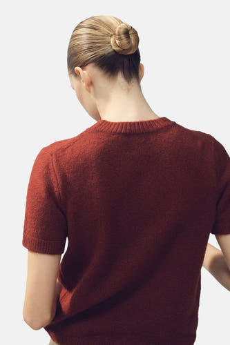Bruine trui met ronde hals van MANGO, gezien van achteren met een strak opgestoken kapsel.
