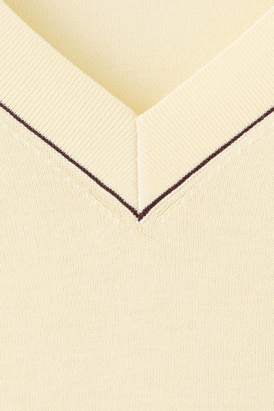 Pull col en V jaune de MANGO, avec une texture en maille fine et un passepoil marron foncé le long de l'encolure.