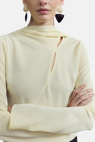 Chemisier jaune à manches longues de MANGO, avec un long col châle et un pantalon noir.