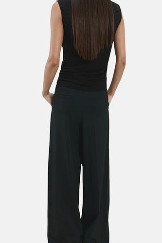 Zwarte mouwloze blouse van MANGO, met rechte pasvorm en lange bruine haren op de rug.