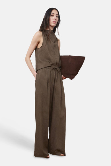 Chemisier marron sans manches de MANGO, avec un motif texturé et associé à un pantalon large et un tote bag.