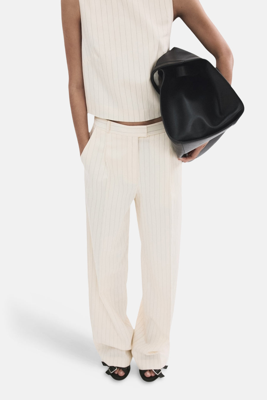 Pantalon blanc de MANGO, à rayures verticales et jambes larges, vu de dos.