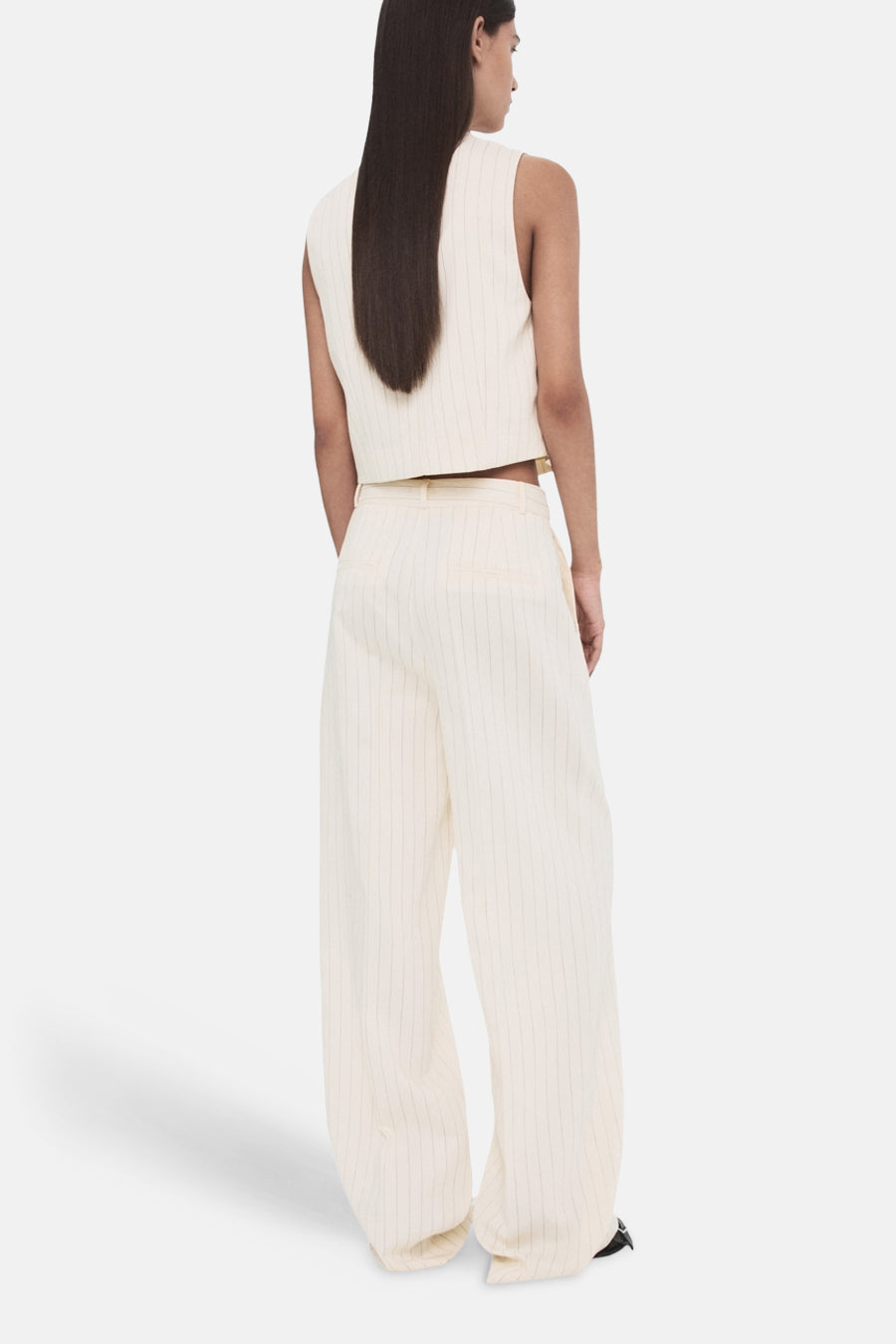 Witte broek van MANGO, met verticale strepen en wijde pijpen, gezien van achteren.
