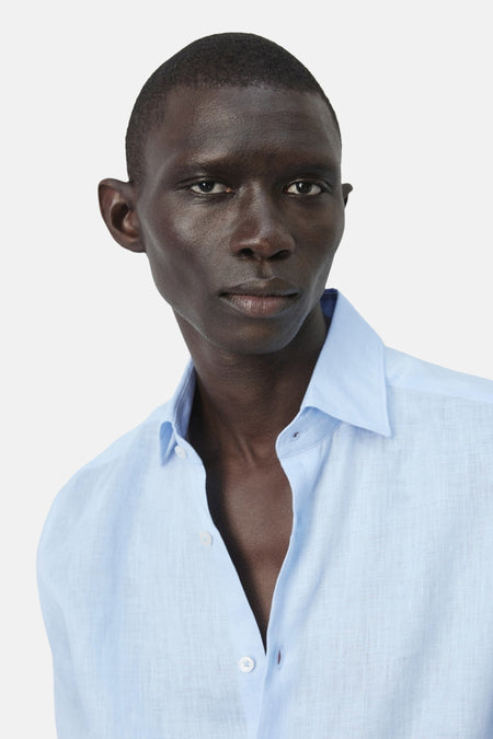 Chemise bleue de MANGO, à manches longues, col ouvert et fermeture boutonnée.