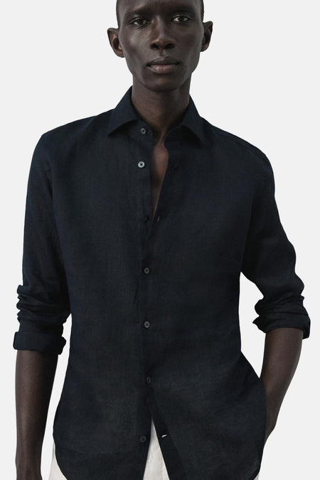 Chemise bleue à manches longues de MANGO, col ouvert et fermeture boutonnée visible.