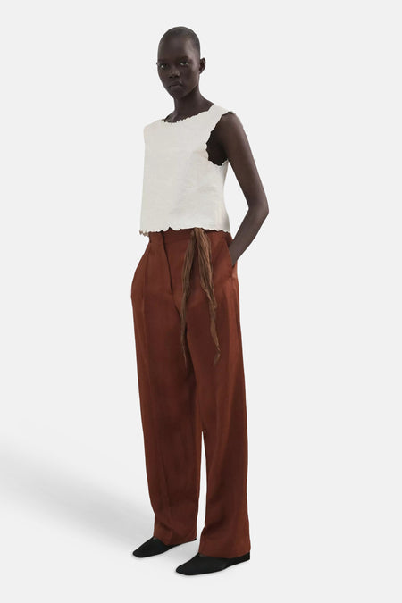 T-shirt blanc MANGO à bords festonnés, porté par un mannequin avec un pantalon marron.