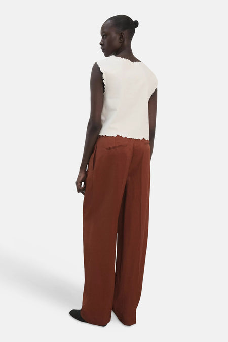 Wit T-shirt van MANGO met geschulpte randen, aan de achterkant gedragen met een bruine broek.