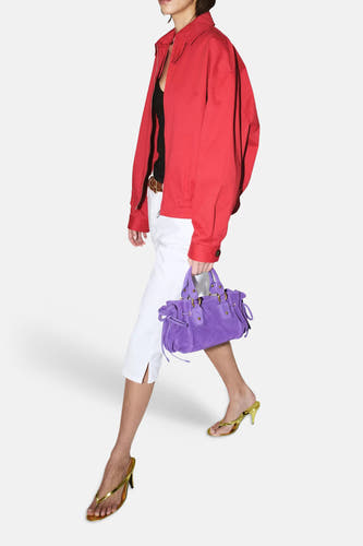 Pantalon blanc 5 poches de MANGO, longueur capri avec fentes, stylisé avec une veste rouge et un sac violet.