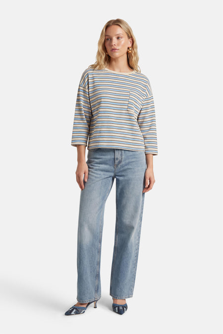 Blauw gestreept T-shirt met lange mouwen van Terra di Siena, met een borstzak en gecombineerd met blauwe jeans en blauwe hakken.
