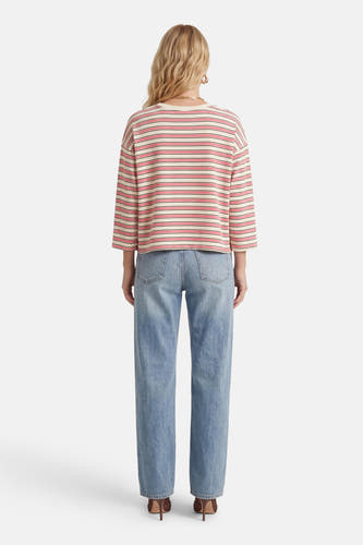 T-shirt rose à manches longues de Terra di Siena, à motif rayé et combiné avec un jean bleu et des talons.