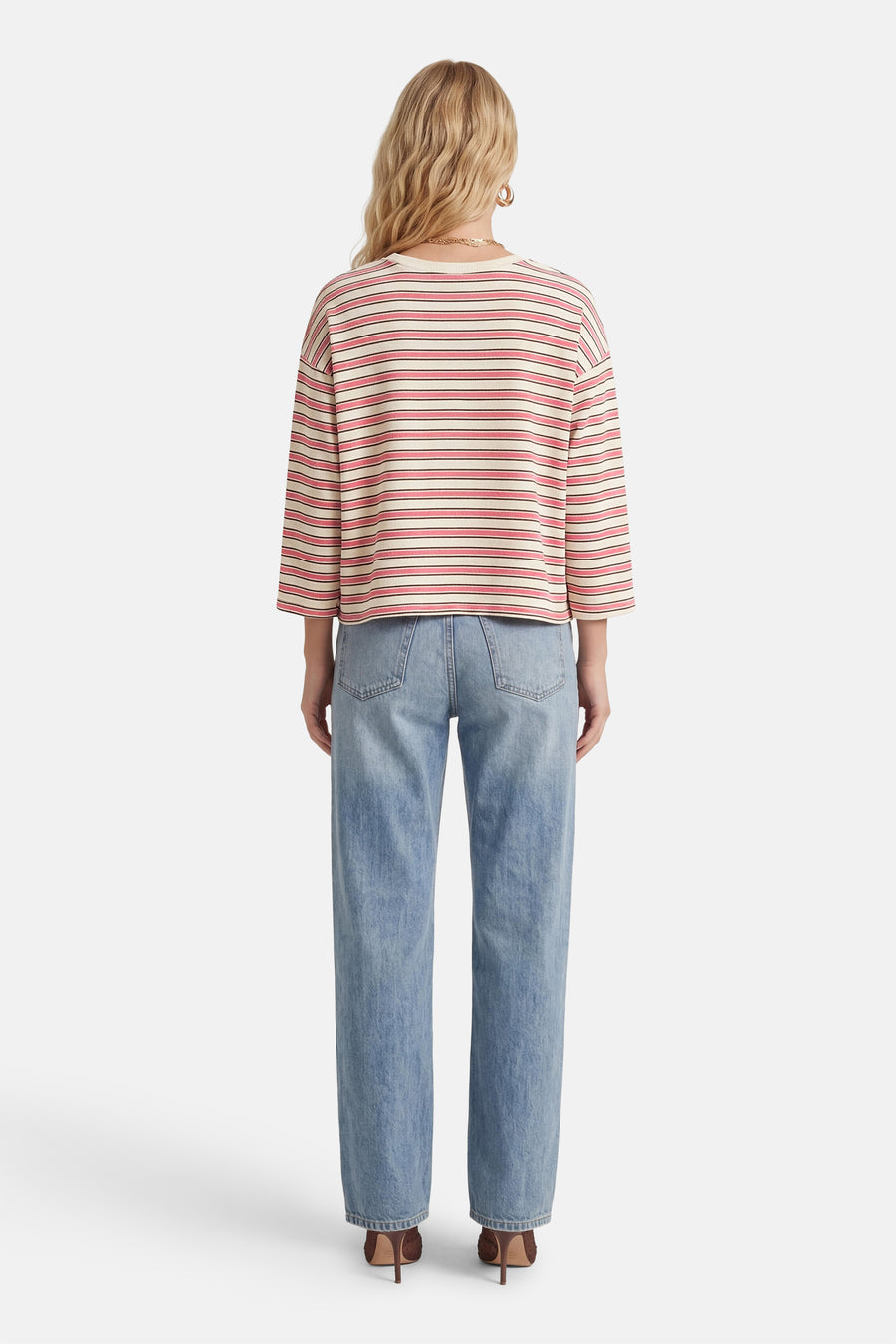 T-shirt rose à manches longues de Terra di Siena, à motif rayé et combiné avec un jean bleu et des talons.