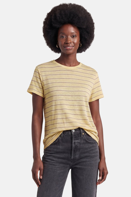 T-shirt jaune à rayures de MANGO à manches courtes, porté par un mannequin dans un jean foncé.