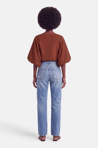 Oranje blouse met korte pofmouwen van Terra di Siena, achterzijde weergegeven op model in lichtblauwe jeans