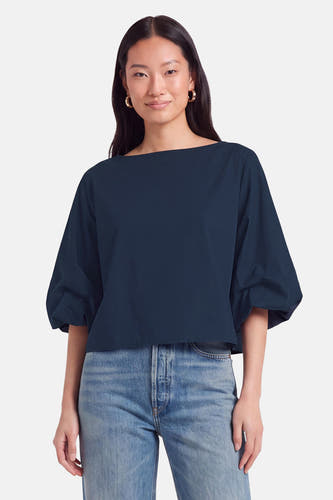 Blauwe blouse met korte mouwen van Terra di Siena, breed model met ronde hals, gedragen met jeans en gouden oorbellen