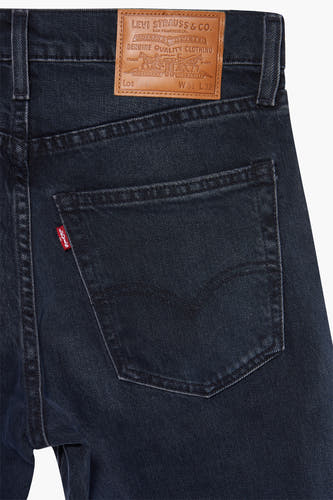 Jean tapered bleu marine de Levi's®, avec une boucle rouge et un étiquette en cuir marron à l'arrière.