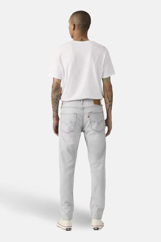 Jean fuselé en denim bleu clair de Levi's, avec vue sur l'arrière et détails des chaussures.