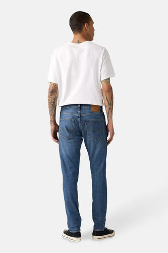 Jean bleu en denim de Levi's, avec une coupe moulante, vu de derrière, associé à un T-shirt blanc.